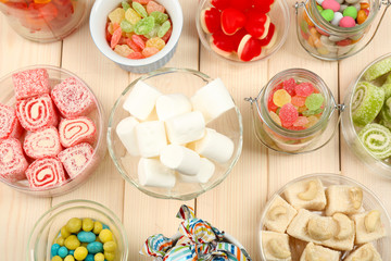 Sweetness in different containers on wooden background