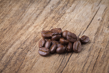 roasted coffee beans in wooden spoon placed on coffee beans as b