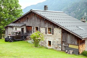 Fototapeta premium Old house and vintage car in the european Alps