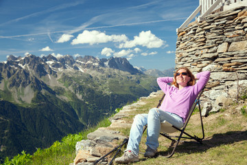 Naklejka premium The woman rests on a summer slope in Alps
