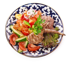 Meat on a grill with vegetables