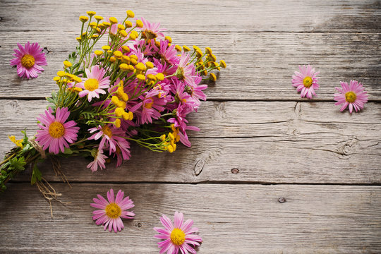 bouquet of pink and yellow flowers on wooden background