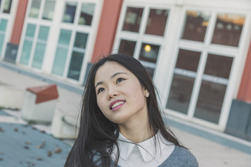 Young beautiful Chinese girl posing in the city streets