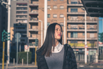 Young beautiful Chinese girl posing in the city streets