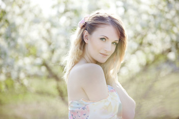 Naklejka premium beautiful blonde girl in the garden on a sunny day