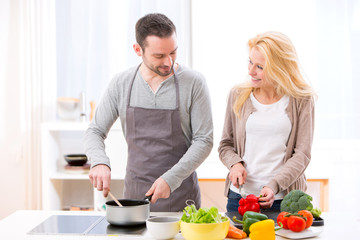 Young attractive couple cooking in a kitchen