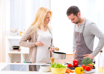 Young attractive couple having an argue while cooking