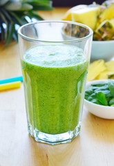 Green spinach and pineapple smoothie on table