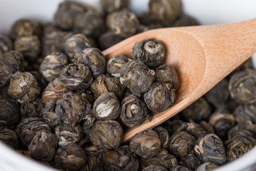 Dry oolong tea leaves in wooden spoons