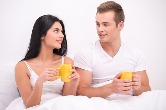 Couple in bed drinking tea or coffee