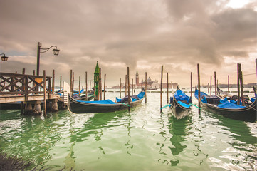 Gondolas docked to the poles on the Grand Canal in Venice.