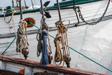 Obraz premium Part of sailing ship with pulleys and knotted ropes.
