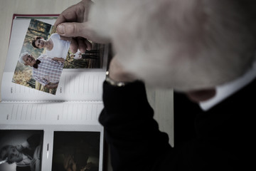 Windowed man watching photo album