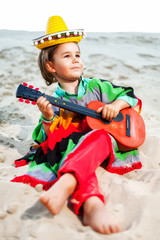 Toned photo of Little happy smiling boy plays his guitar