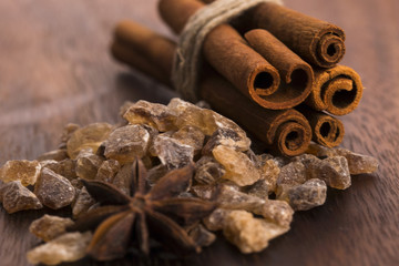 Obraz na płótnie Canvas Cinnamon sticks with pure cane brown sugar on wood background