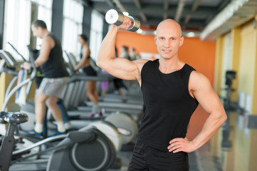 Fototapeta na wymiar Muscular guy doing exercises with dumbbell