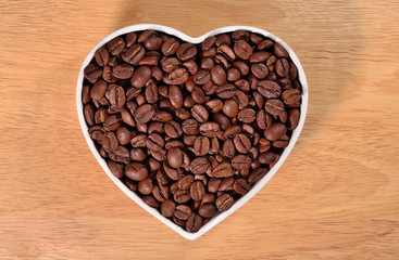 Coffee beans in plate in the form of heart