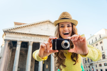Smiling young woman taking photo in front of pantheon in rome