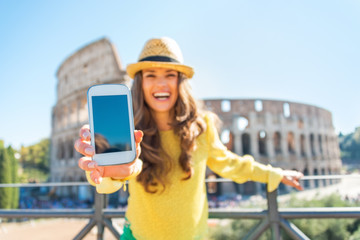 Fototapeta premium Closeup on happy young woman showing cell phone in Rome