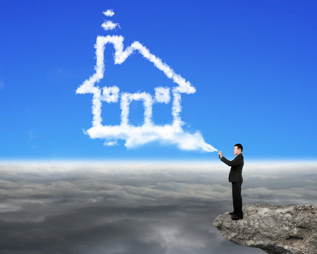 Businessman Spraying House Shape Cloud Paint On The Cliff