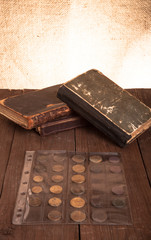 Vintage books and coins on old wooden table