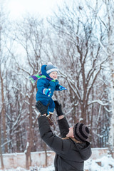 Naklejka na ściany i meble Happy father and baby playing on snow