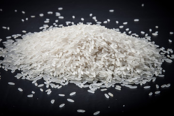 Handful rice on a black background. Toned