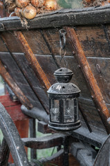 Plakat view of an old oil lamp hanging on a wooden carriage