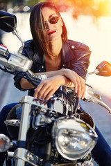 Naklejka na ściany i meble Biker girl in a leather jacket on a motorcycle