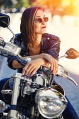Naklejka na ściany i meble Biker girl in a leather jacket on a motorcycle