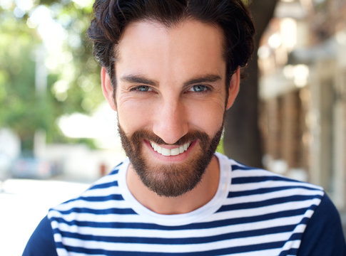 Smiling young man with beard and striped shirt