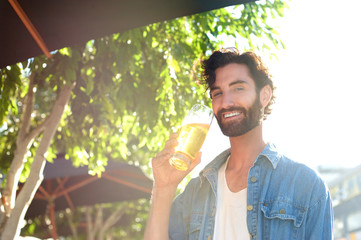 Fototapeta premium Guy drinking beer in summer at outdoor bar