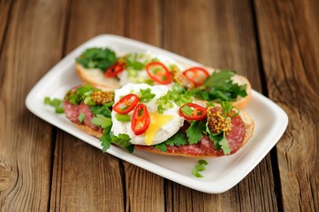 Poached egg sandwiches with chili, scallion and salami selective