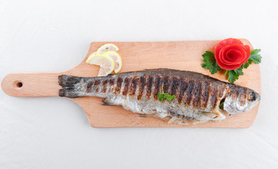 Grilled fish and vegetables on an wooden board