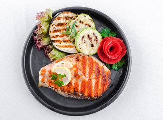 Grilled salmon, sliced zucchini and courgette, lettuce and lemon