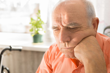 Serious Senior Bald Man with Fist on his Face