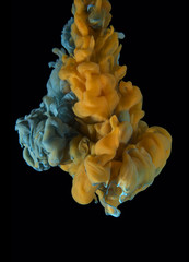 Color drop on black background. Yellow orange, blue.