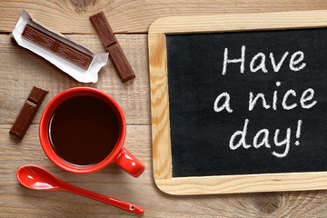 Coffee cup and chalkboard with phrase Have a nice day!