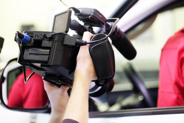 The image of hands holding a professional camcorder