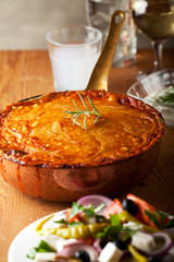 gebackenes Moussakagericht auf einem Holzbrett