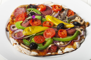 Pizza mit allem auf einem Teller