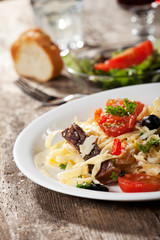 frische Pasta mit Tomaten und Oliven auf einem Teller