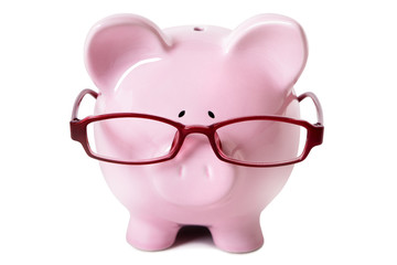 Pink piggy bank wearing glasses isolated on white background photo