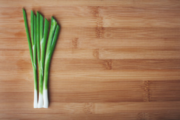 green onions on a wooden background