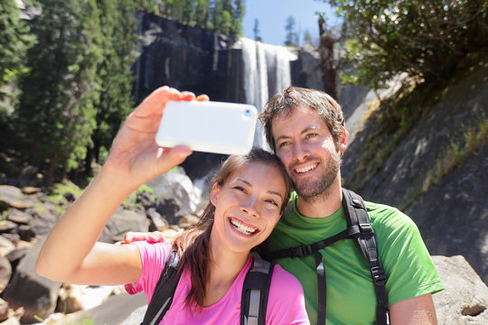 Couple hiking taking smartphone selfie in Yosemite