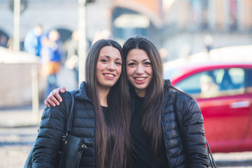 Female Twins Portrait in the City with Traffic on Background.