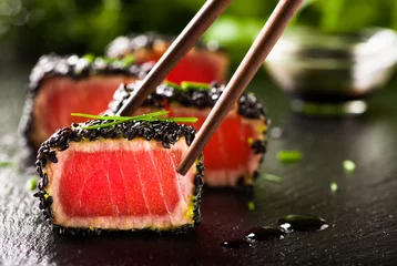 Foto op Plexiglas Gebakken tonijnsteak in zwarte sesam met stokjes © nioloxs