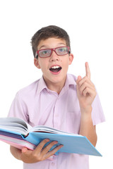 nerdy teenage boy with books pointing his finger up surprised and excited after discovering something