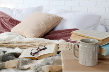 Book and glasses on bed close-up