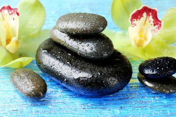 Spa stones with water drops and beautiful blooming orchid